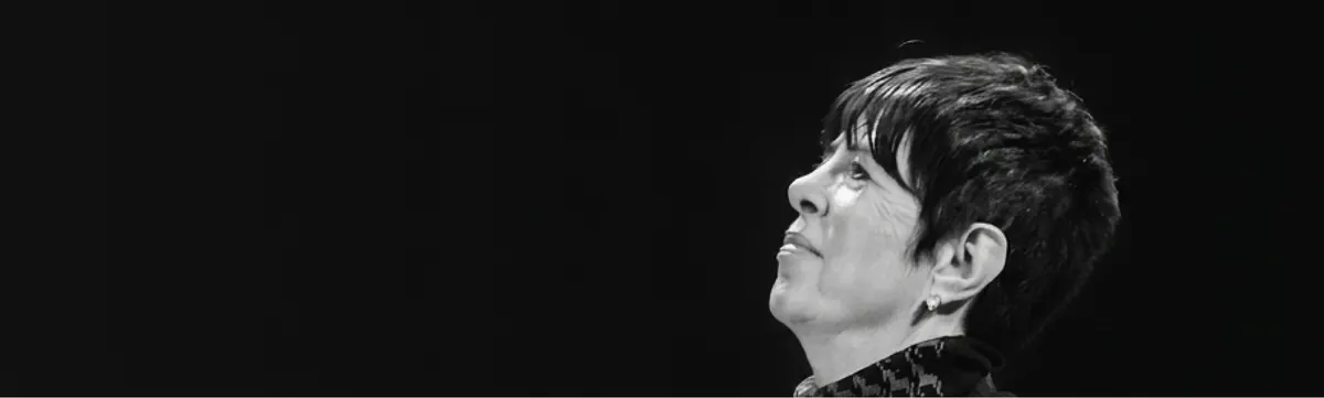A listener in profile looking up towards the stage, in black and white