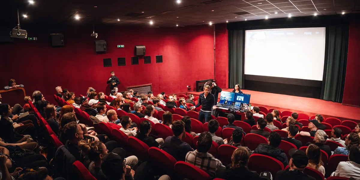 A full red-seated hall at Atlas Cinema during a summit session
