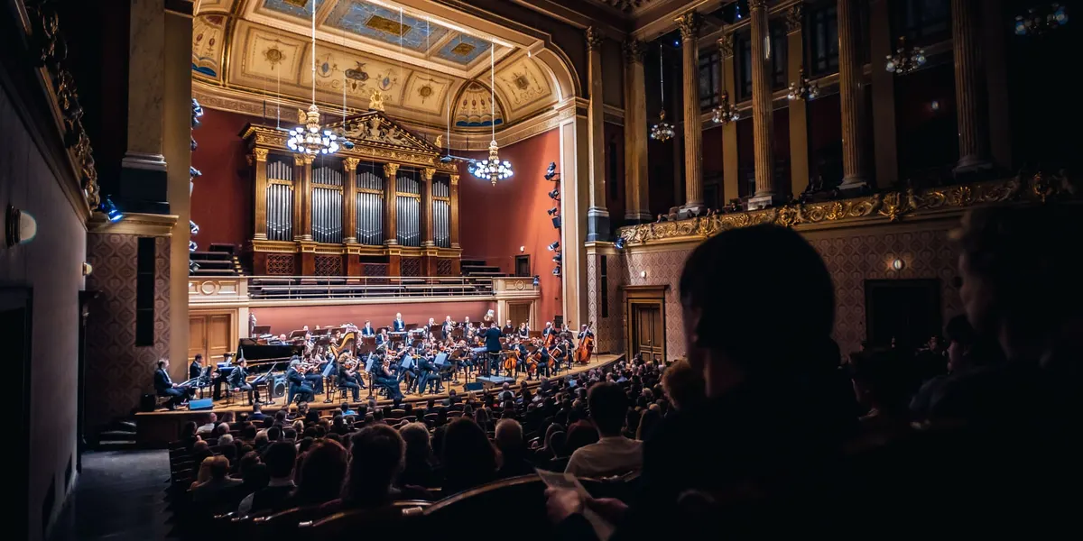 Orchestr a skladatelé při děkovačce na pódiu Rudolfina